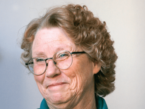 White woman in glasses smiling