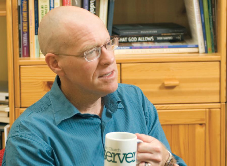 Bald white man in blue shirt holding coffee cup