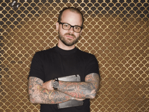 Young white man with tattoos wearing black T-shirt