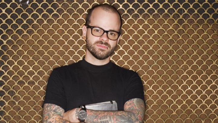 Young white man with tattoos wearing black T-shirt