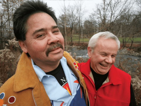 Two men smiling in winter forest