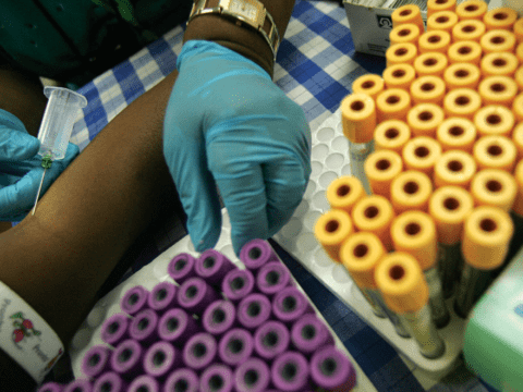 Overhead of Black person talking blood, many vials