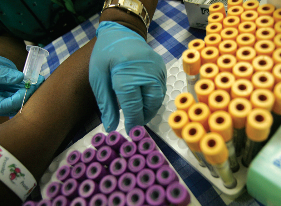 Overhead of Black person talking blood, many vials