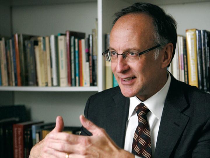 Balding white man in glasses, suit and tie