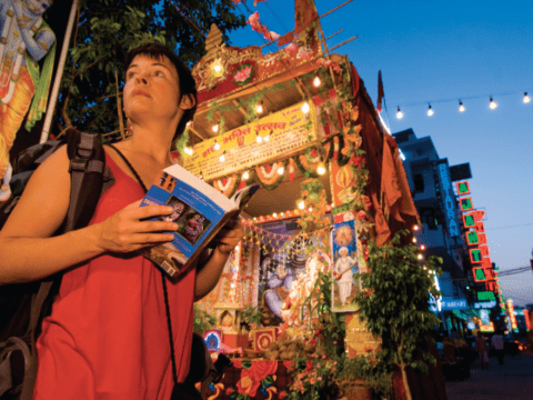Young white woman with tour book in India