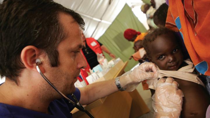 White man with stethoscope examines Black baby