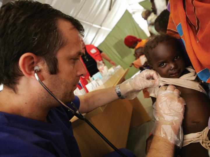 White man with stethoscope examines Black baby