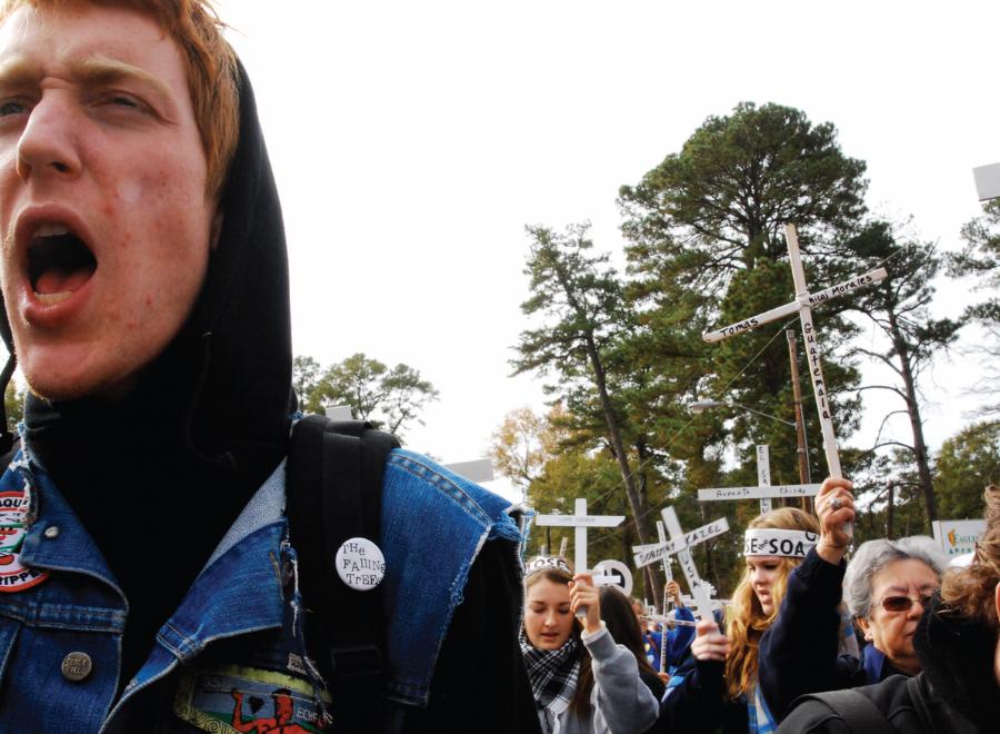 Young white man in hoodie and jean jacket in protest march