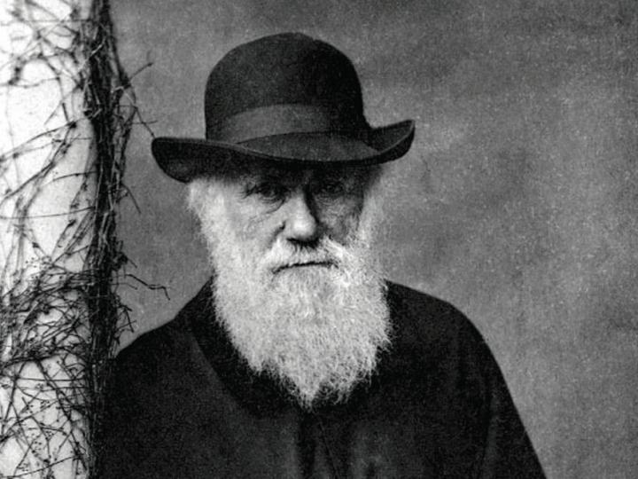 Black and white Victorian photo of elderly man with white beard wearing black hat
