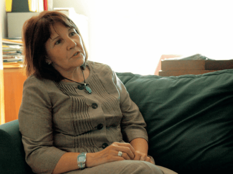 Indigenous woman in suit sitting on green sofa