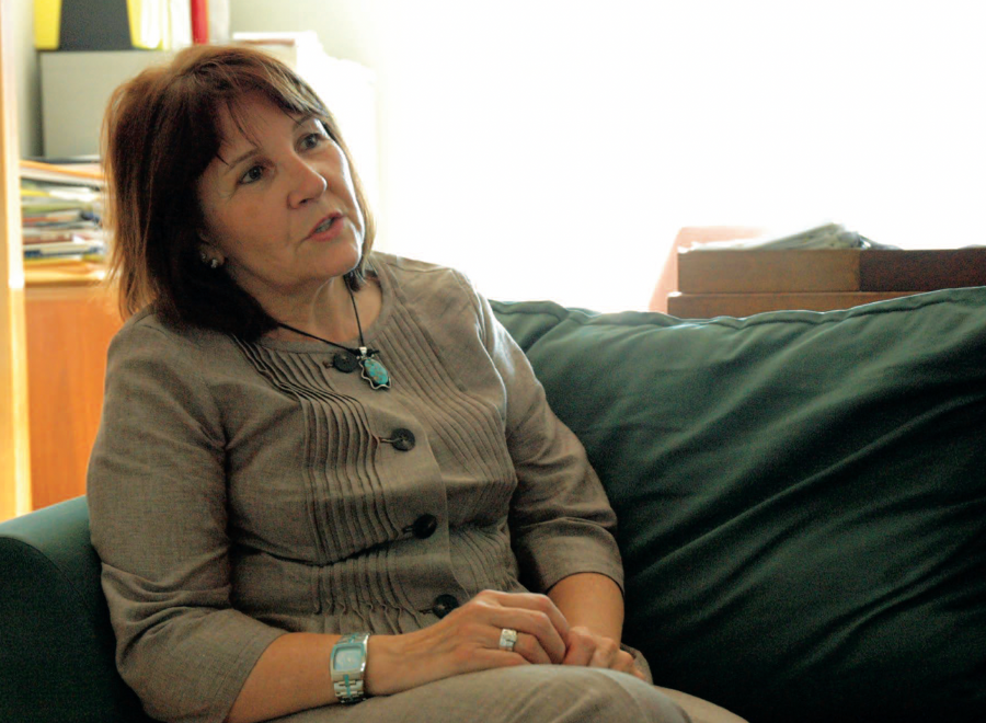 Indigenous woman in suit sitting on green sofa
