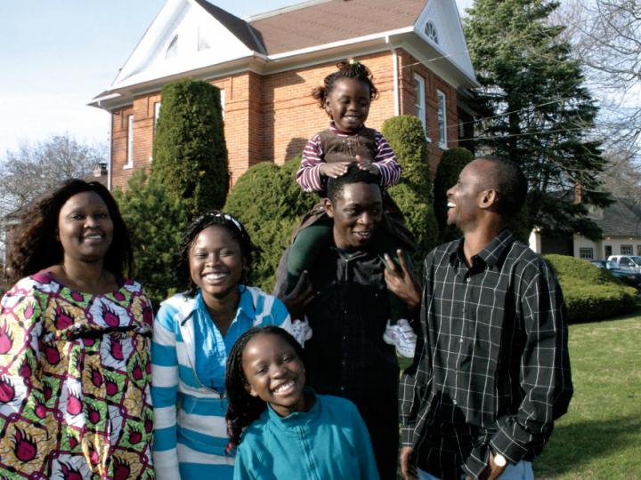 Congolese family of six in front of their brick home in rural Ontario