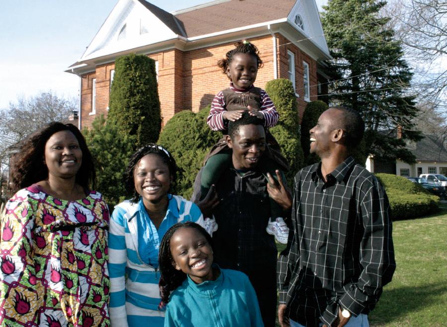 Congolese family of six in front of their brick home in rural Ontario