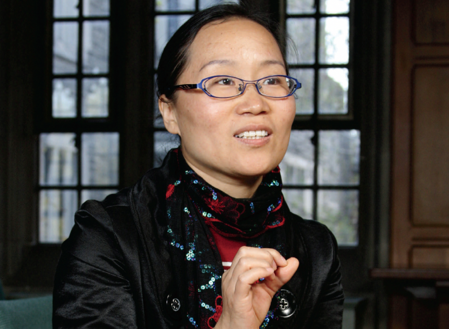 Chinese woman gesturing in front of old-style window