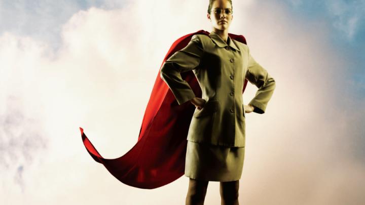 Young white woman in suit with red superhero cape