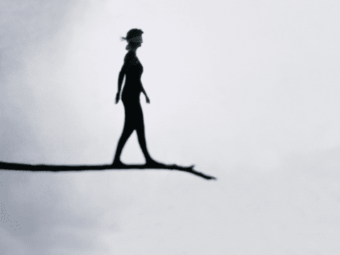 Illustration of blindfolded woman walking on tree branch