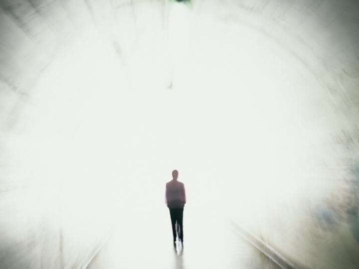 Illustration of a person walking toward a bright light