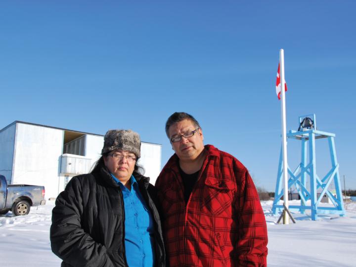 Indigenous couple in winter clothing against blue sky