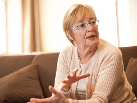 White woman in glasses sitting on a couch