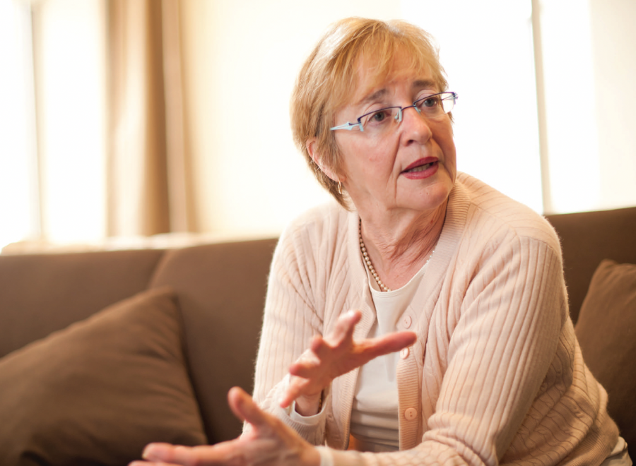 White woman in glasses sitting on a couch