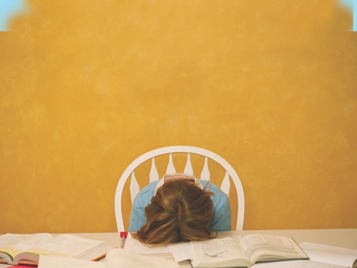 student with head down on books