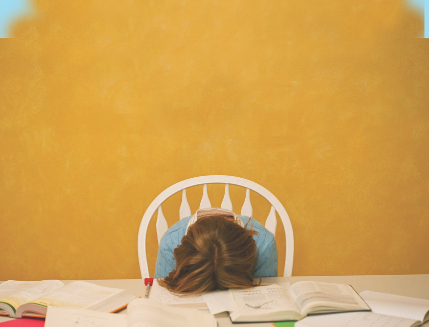 student with head down on books