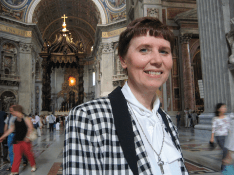 White woman in church smiling at camera
