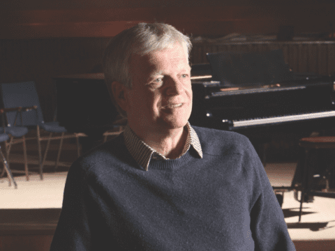 White man standing in concert hall