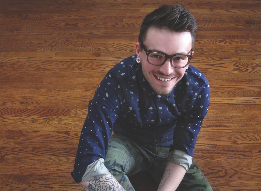 Young white man sitting on wooden floor looking up into camera