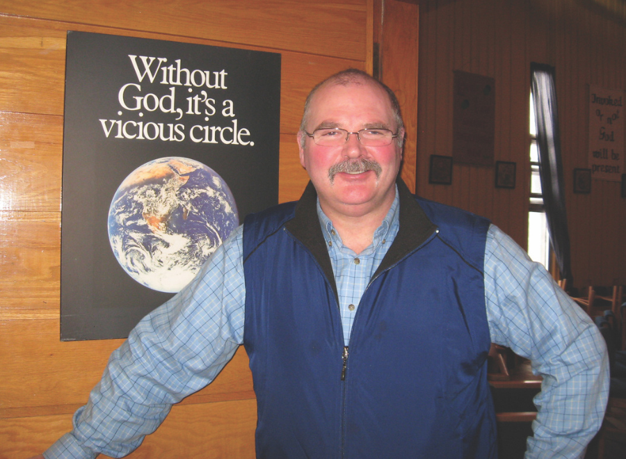 Man with glasses and mustache looks at camera
