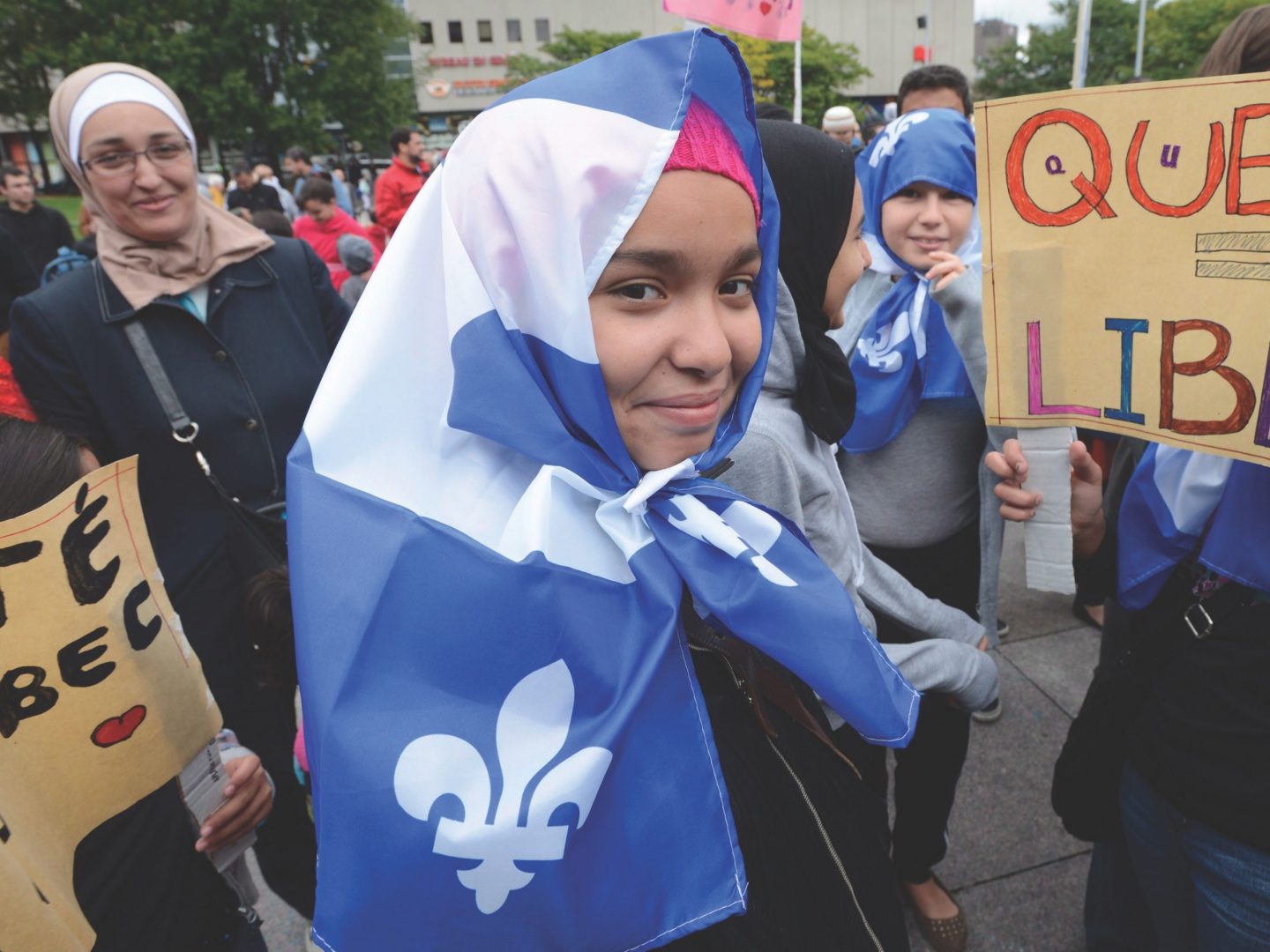 woman with headscarf made of quebec flag at march