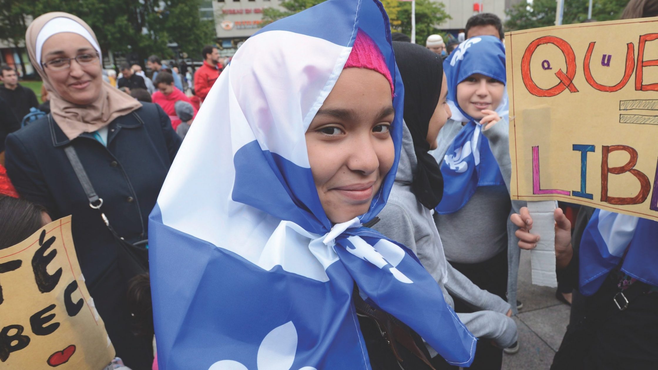 woman with headscarf made of quebec flag at march