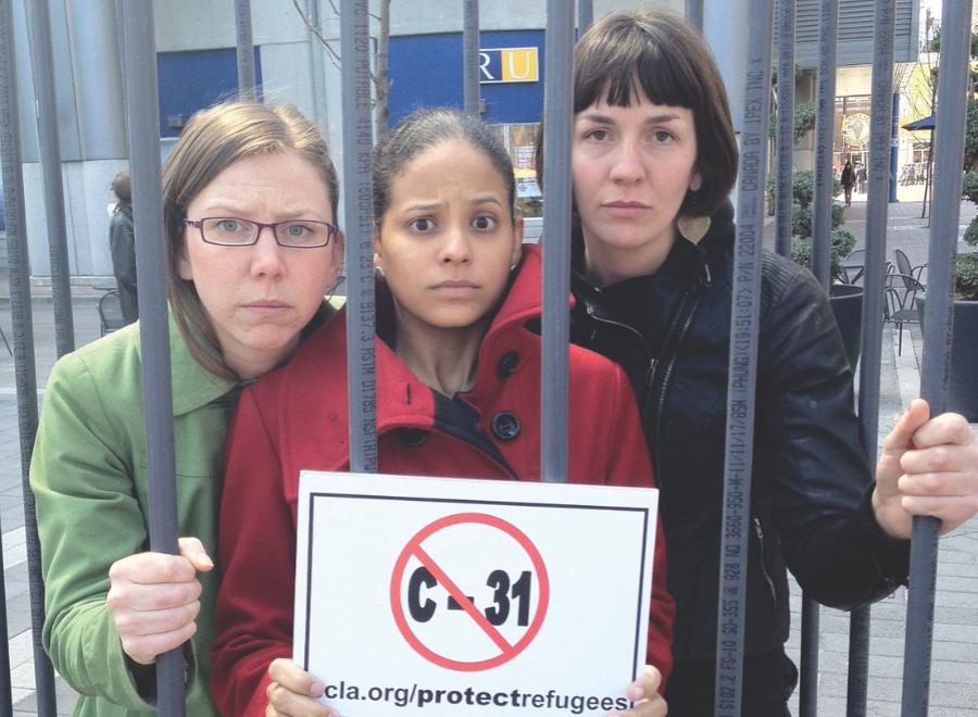 three women behind bars holding sign