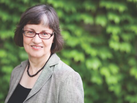 woman with glasses looking into camera