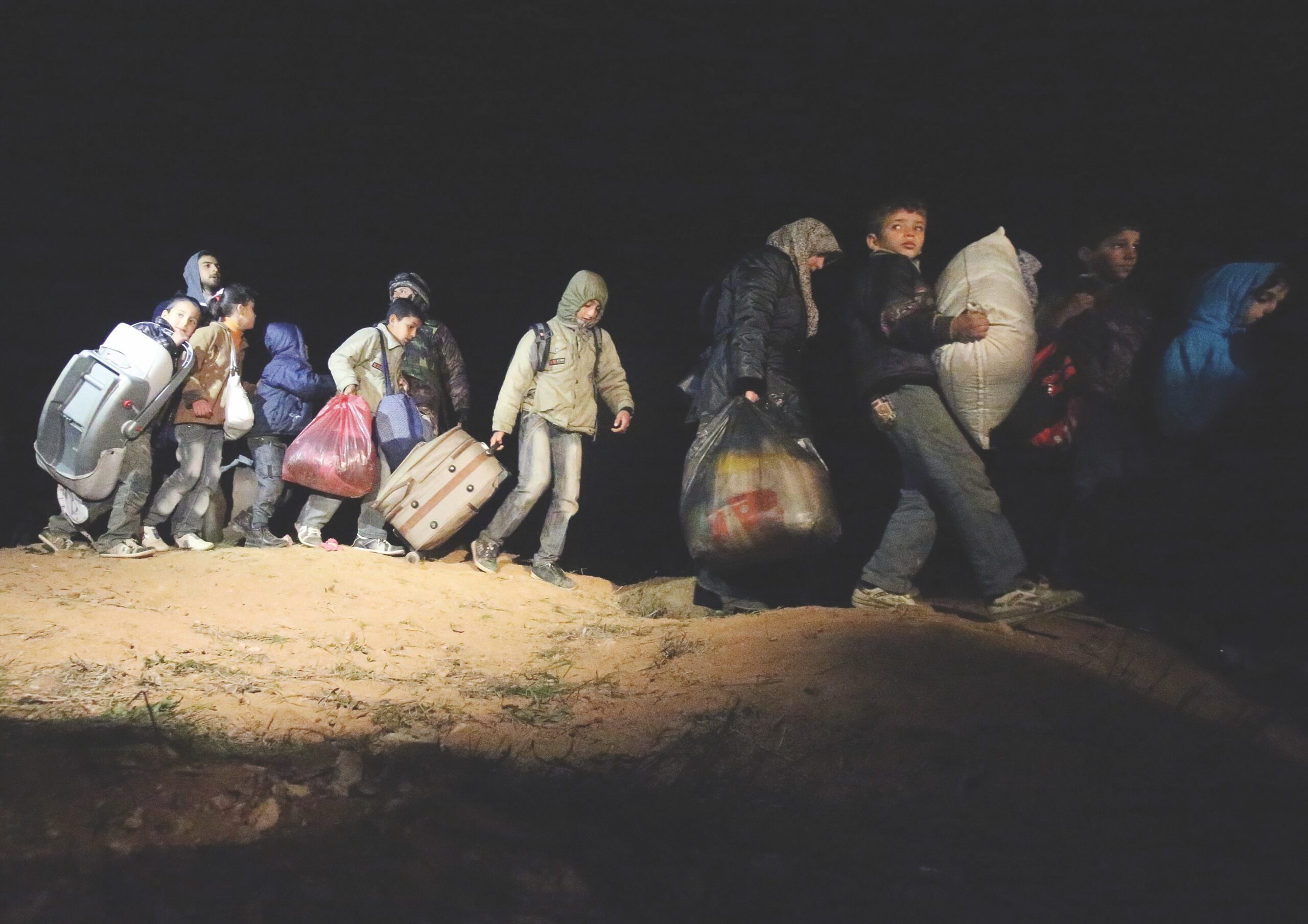 string of people walking with belongings