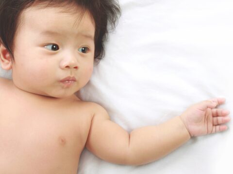 Baby lying on sheet