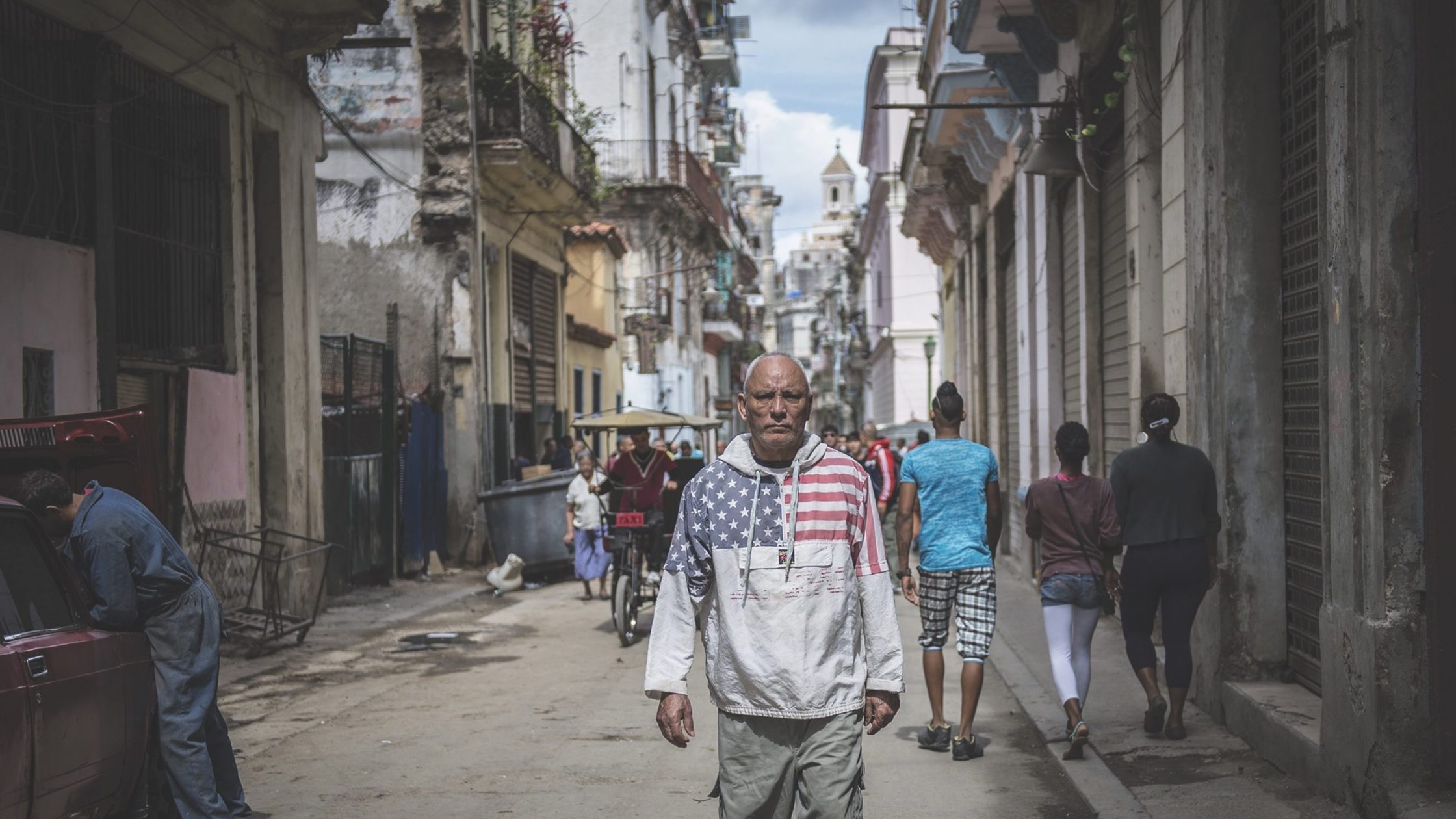 Man standing in Cuban street with US flag on shirt