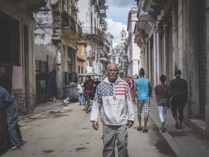 Man standing in Cuban street with US flag on shirt