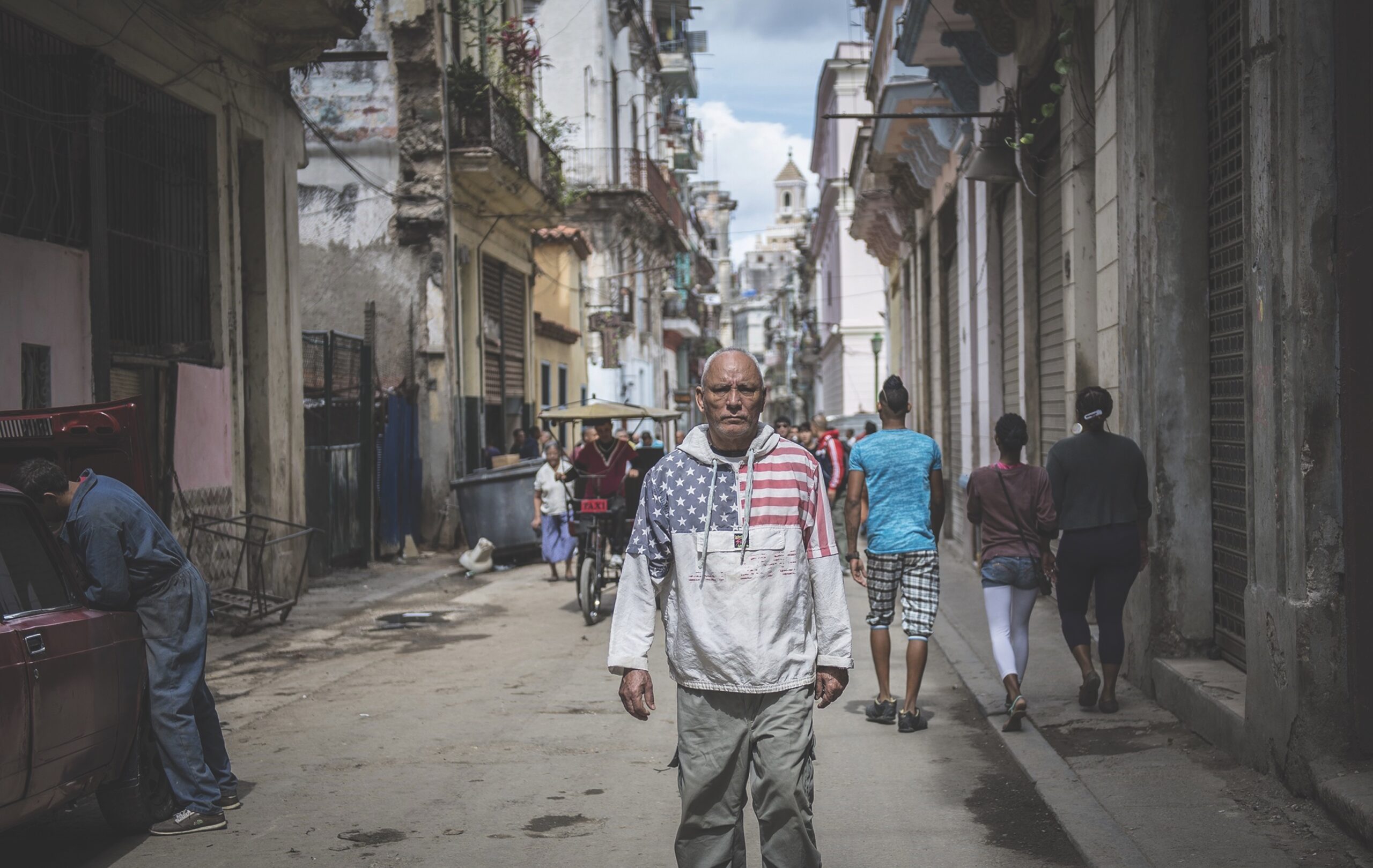 Man standing in Cuban street with US flag on shirt