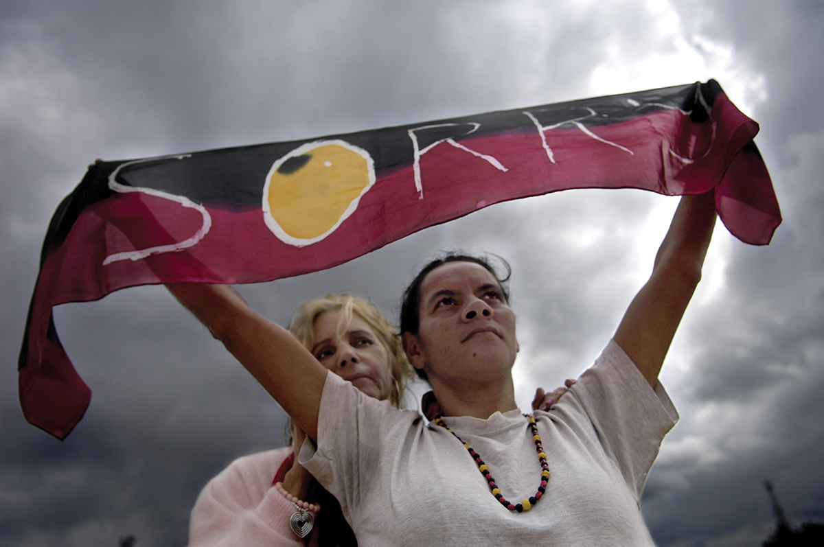 Rhonda Randall (left) and Sharon Mumbler stand proud with their “sorry” scarf as Australia’s prime minister delivers an apology to Indigenous peoples of Australia in 2008. Photo by David Hill/Newspix/Getty Images