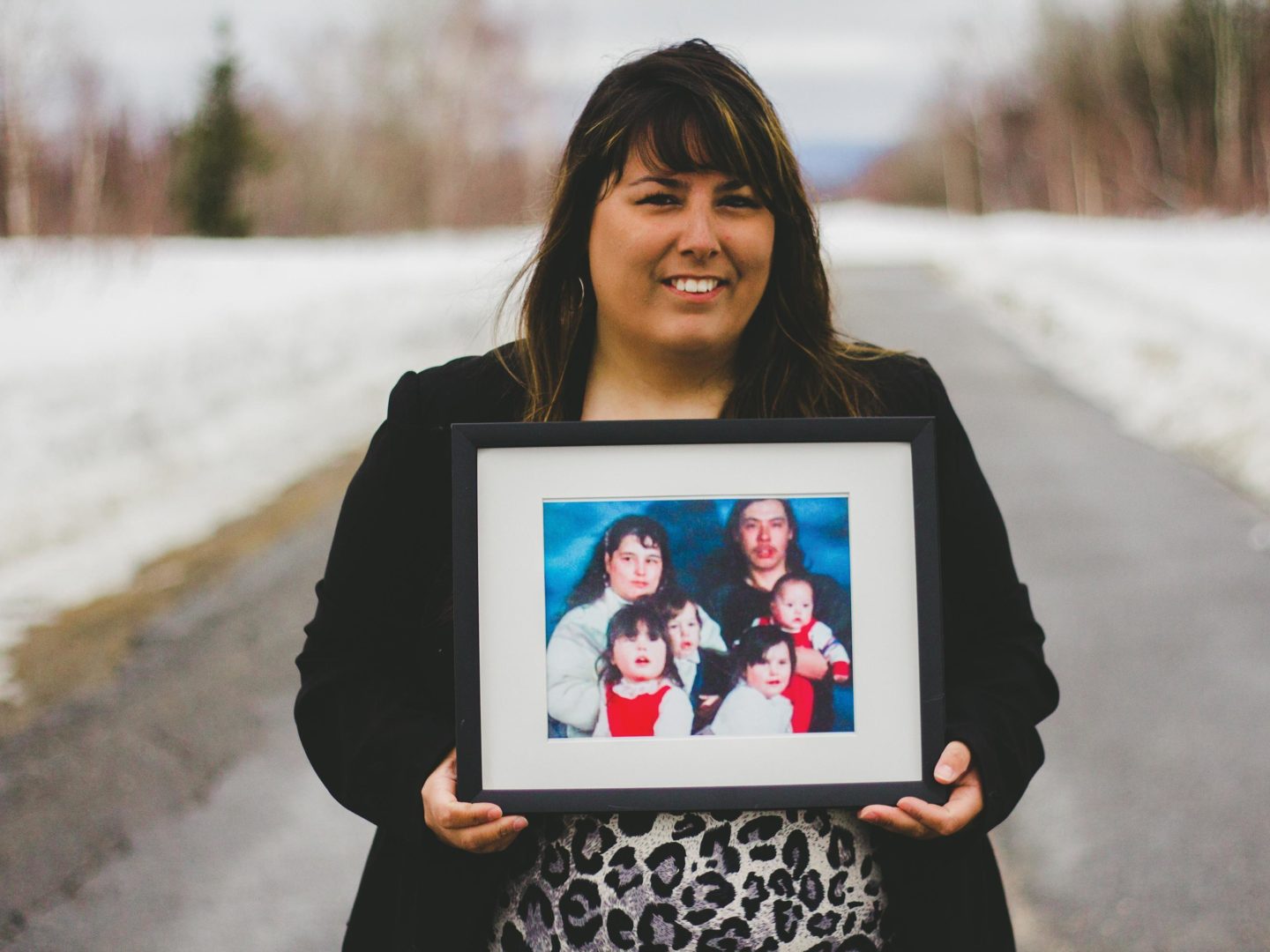 Becky Michelin holds a family photo showing her mother, Deidre (back left). Photo by Becky Michelin