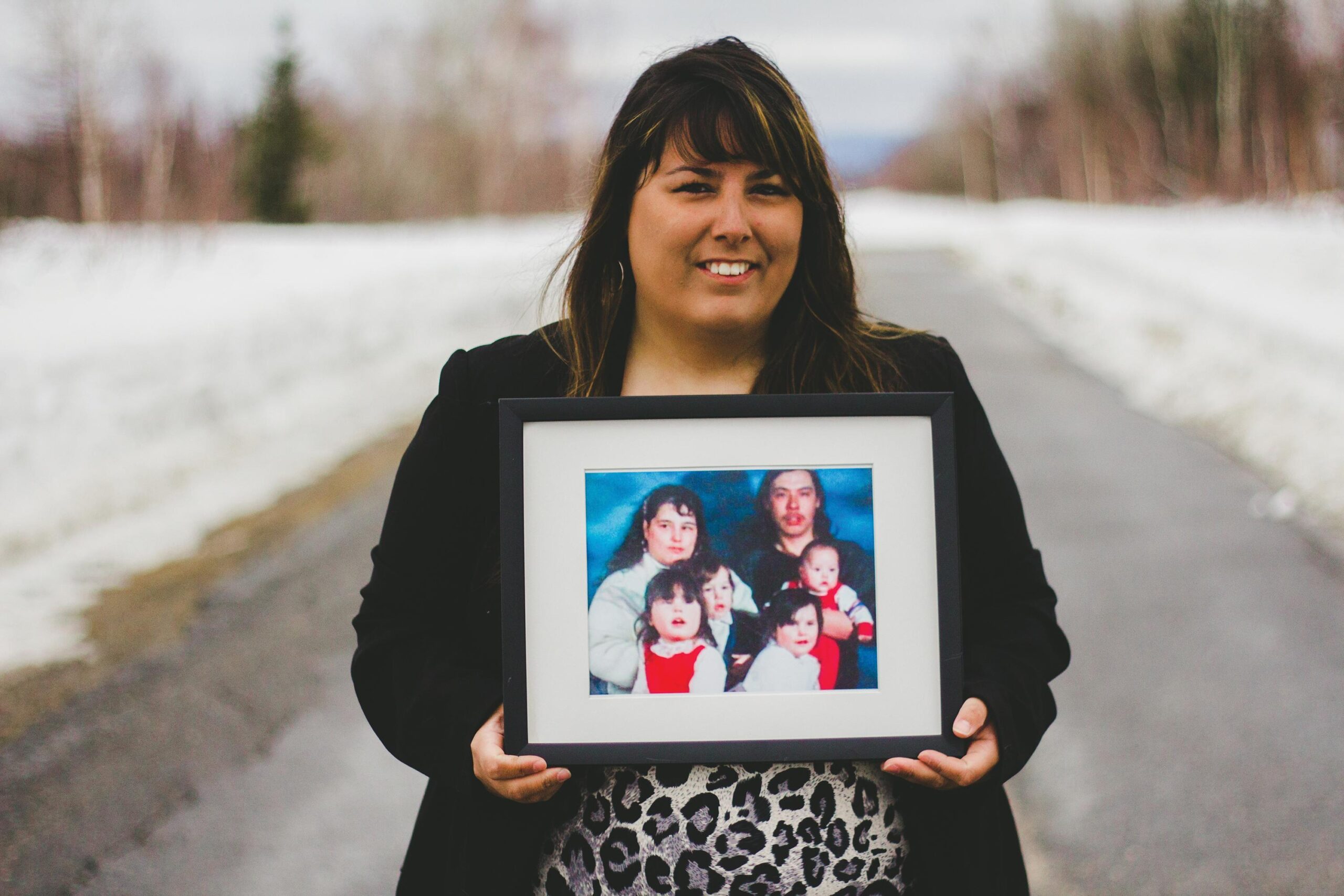 Becky Michelin holds a family photo showing her mother, Deidre (back left). Photo by Becky Michelin