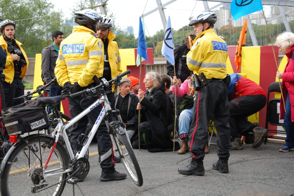 Protesters sit and face police during the demonstration. (Photo: Aleysha Haniff)