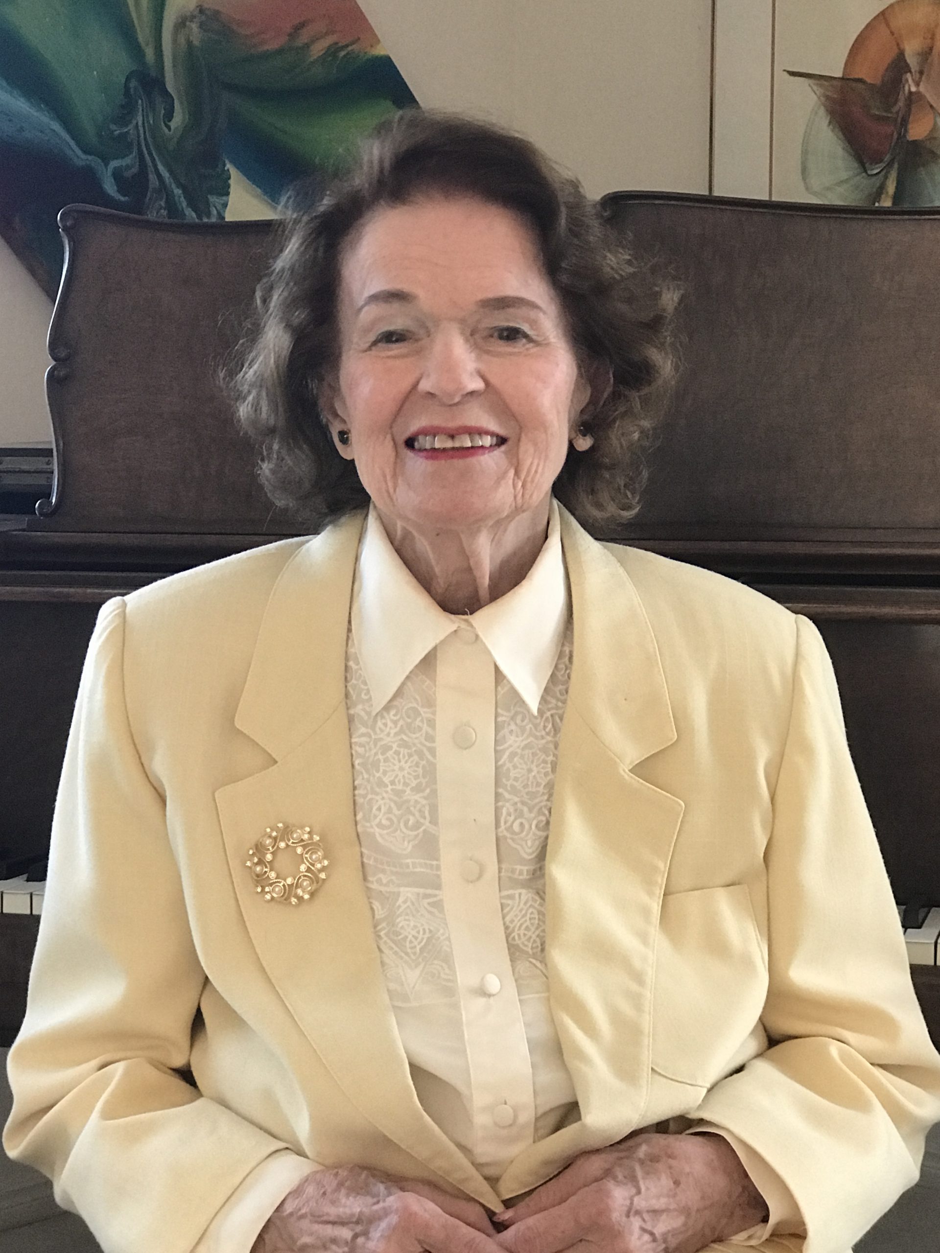 Elizabeth Bonnell McCuaig Newton sits in a yellow suit.