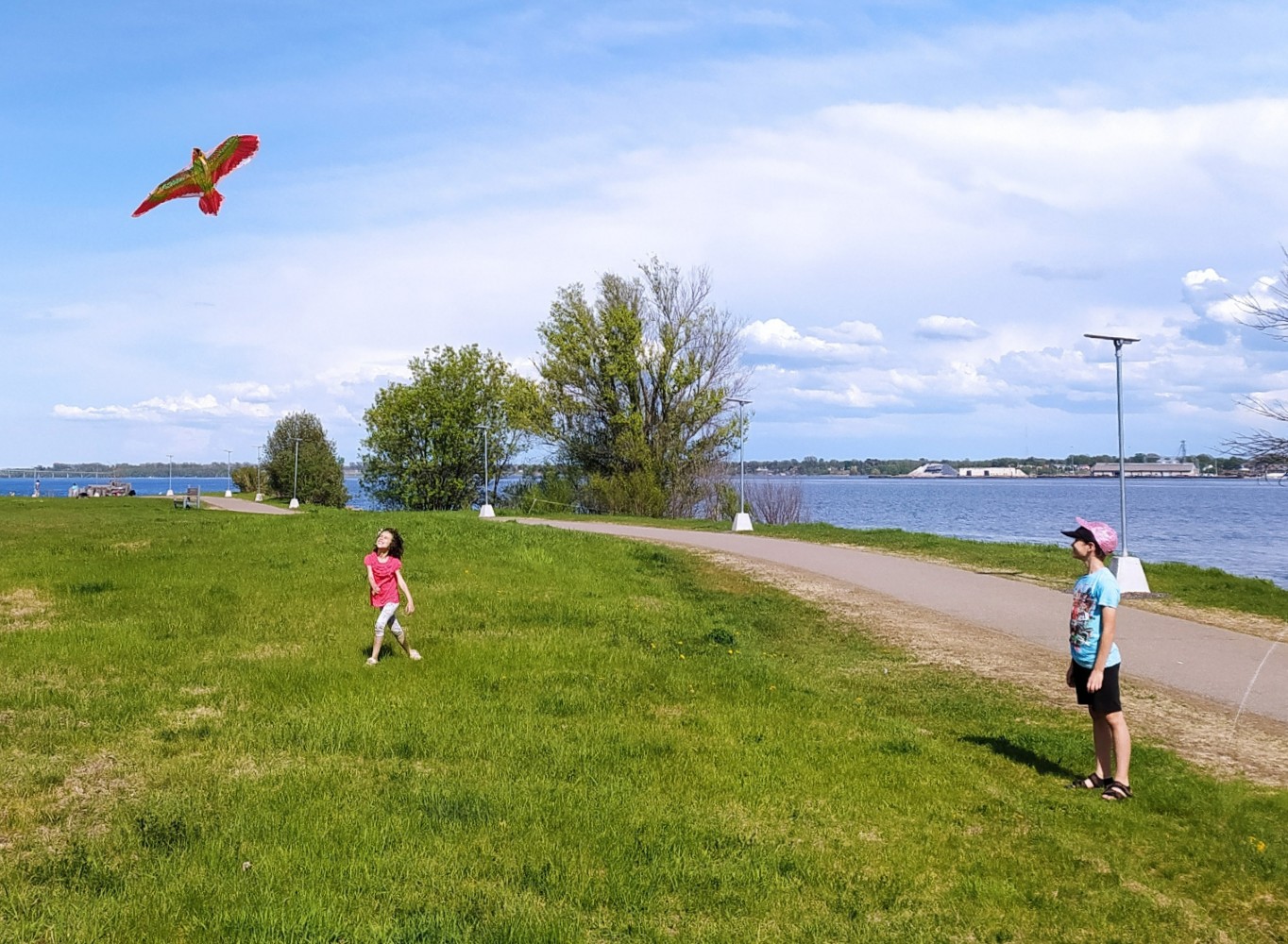 Maryna's children Timur and Liana by Prescott's waterfront, looking at a kite in the sky