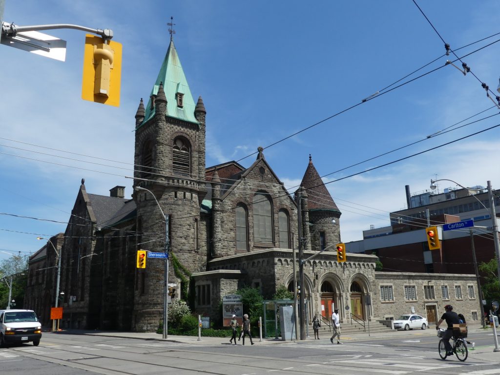 Saint Luke's, a large church with a turquoise tower, stands at the intersection of Sherbourne and Carlton 