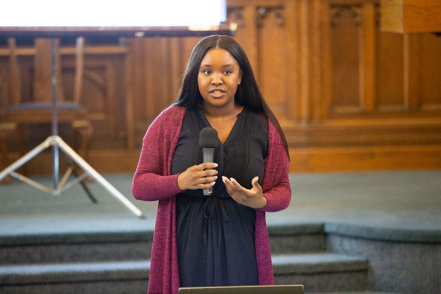 Jordana Wright speaks into a microphone inside the main congregating room of East End United Church