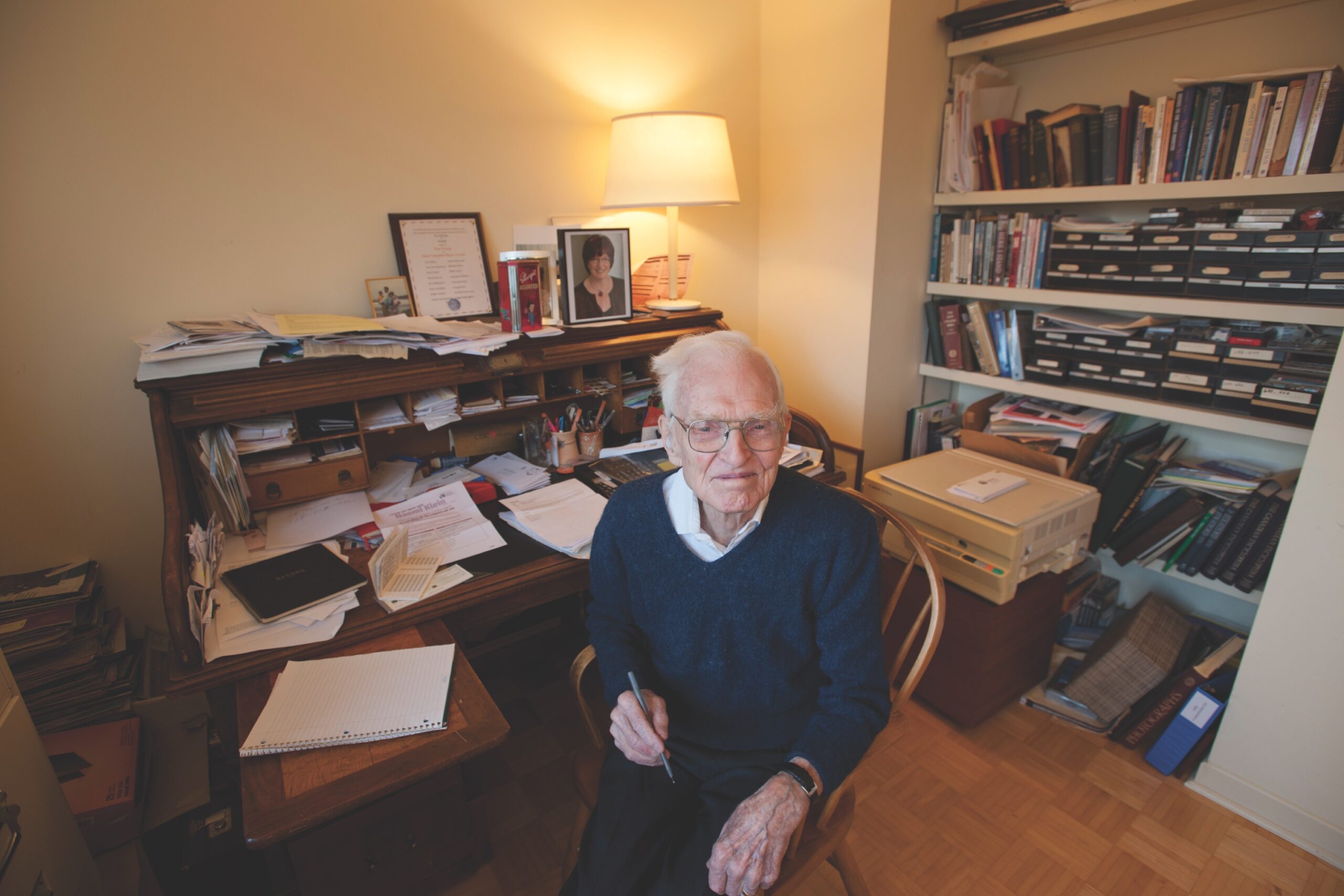 elderly man sitting at his desk