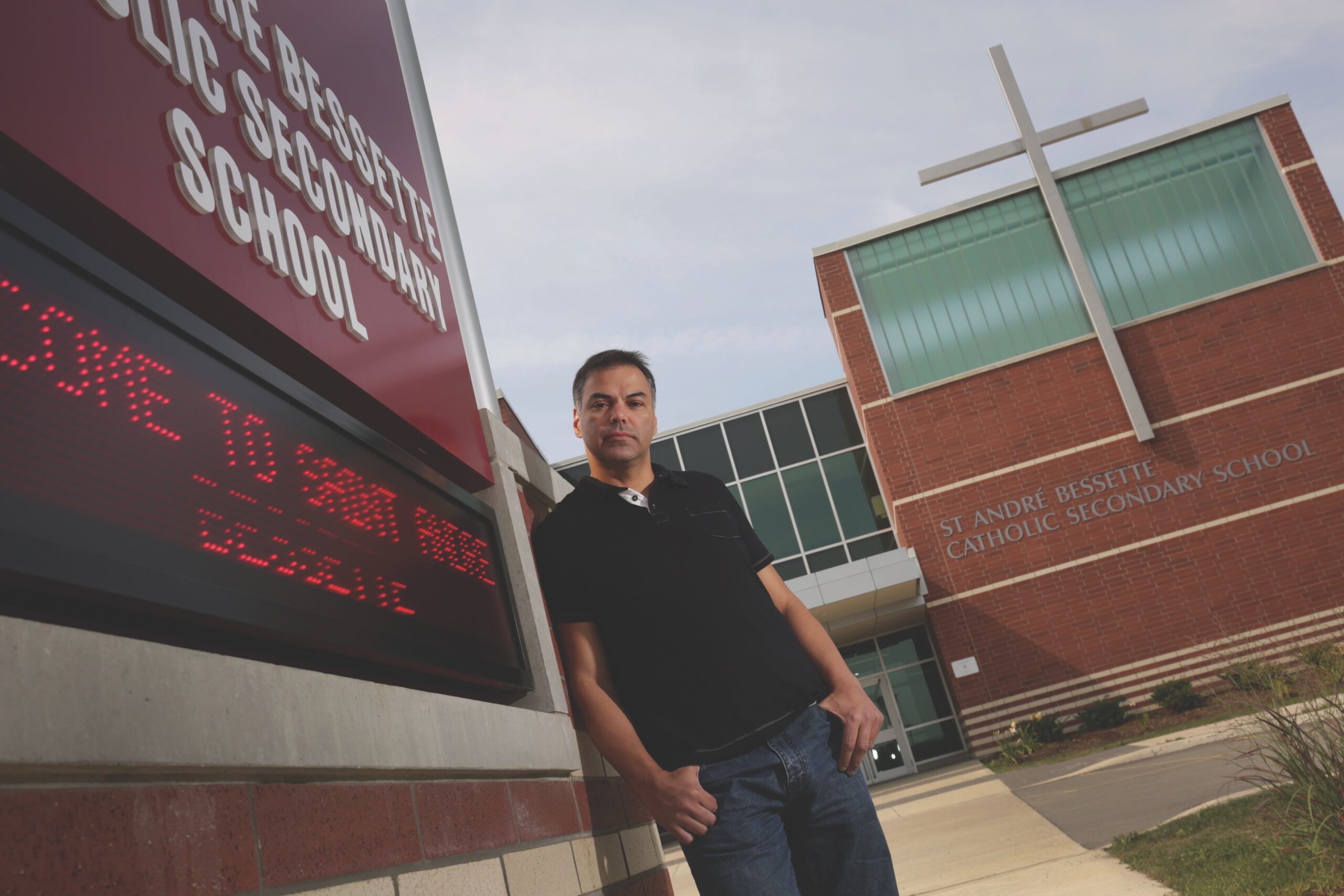 Father stands in front of school