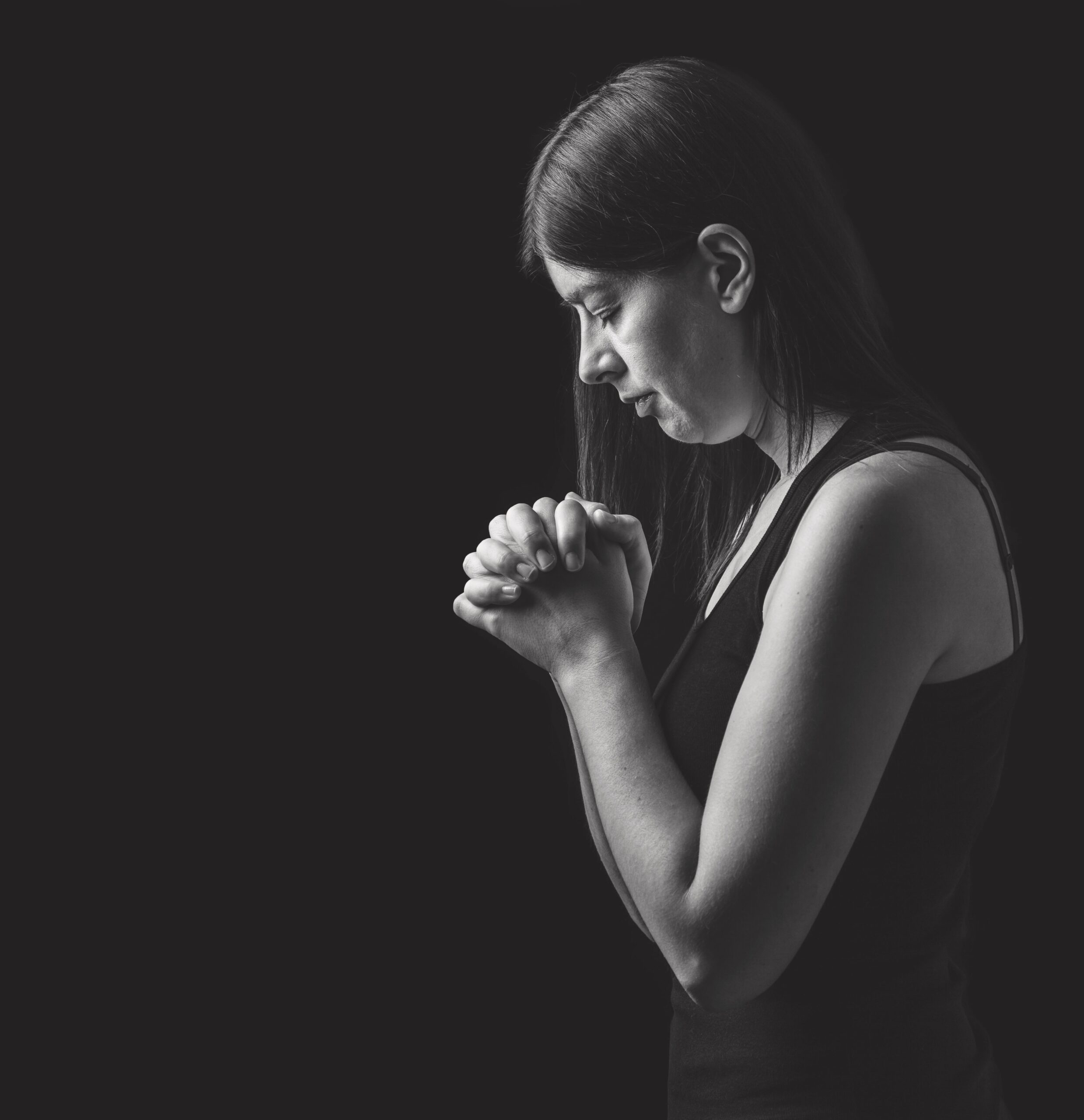 Woman praying with clasped hands